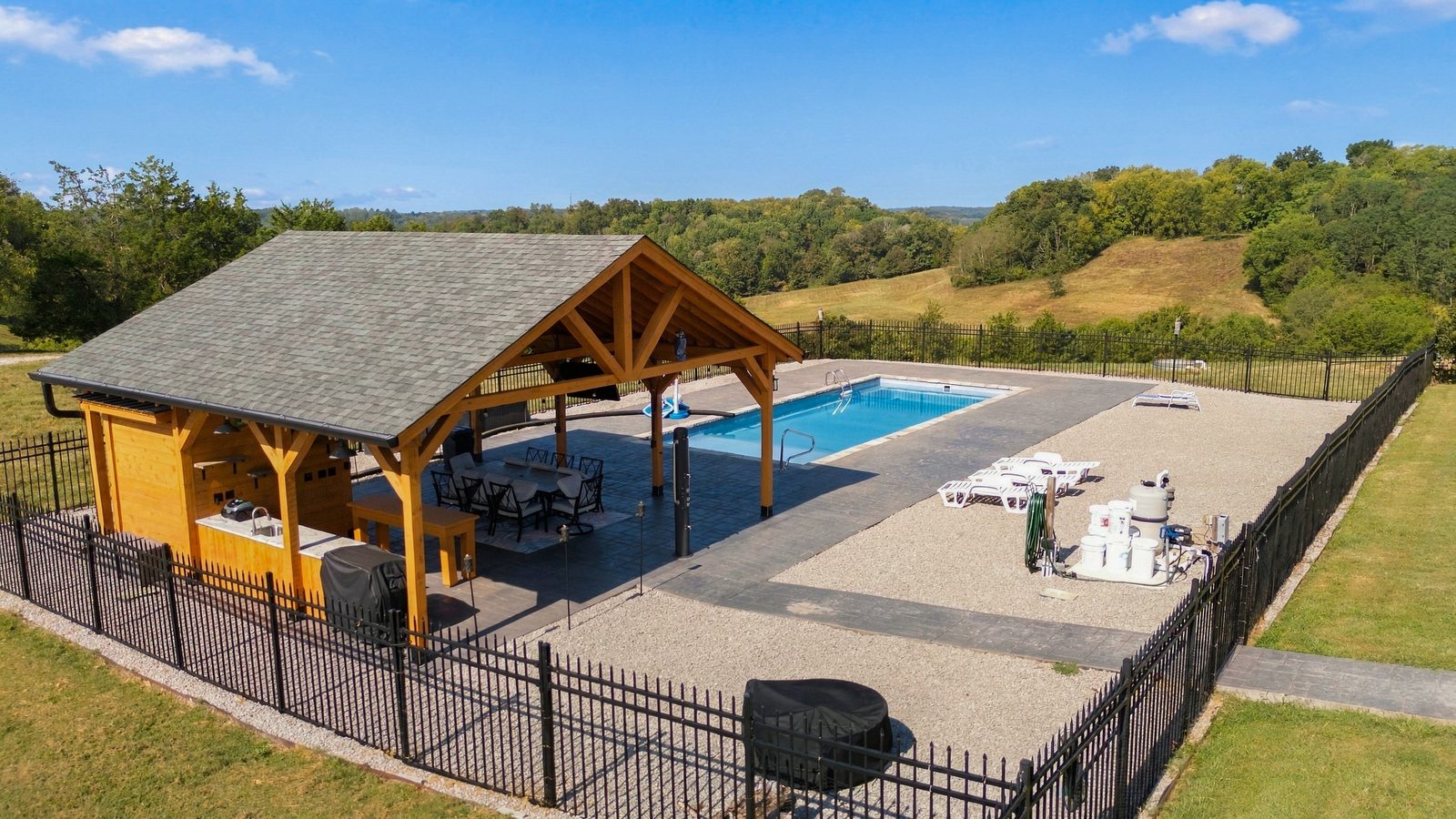 The covered post-and-beam cabana and outdoor kitchen overlooking the pool and ridge