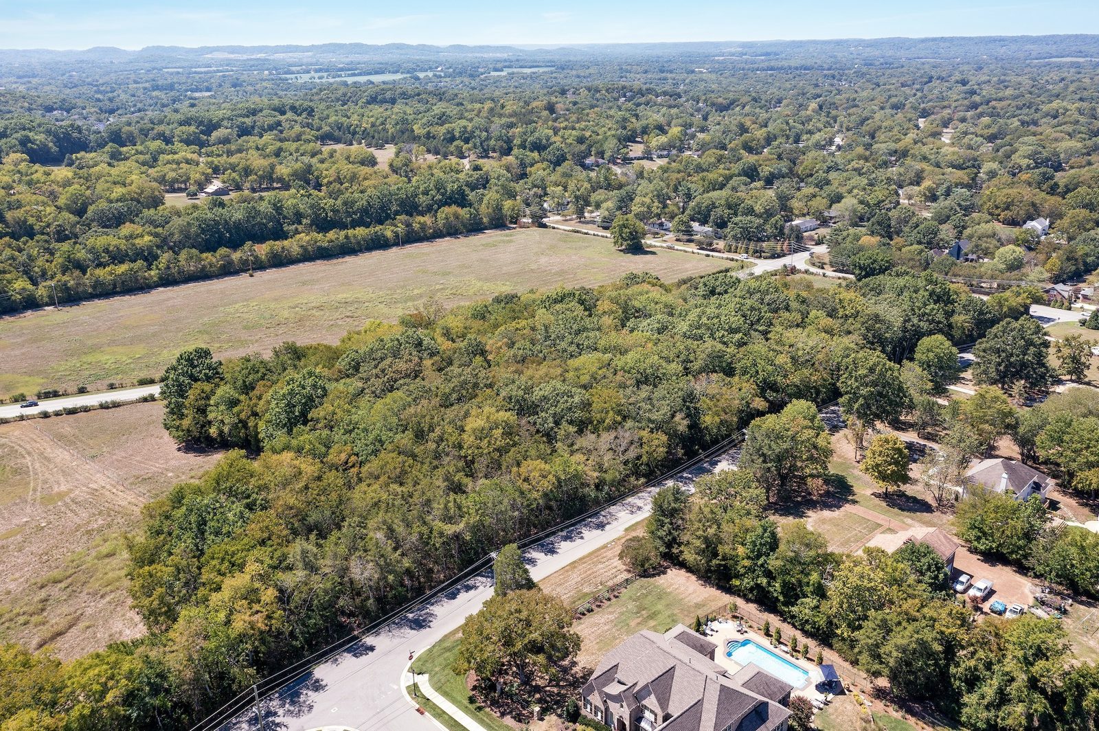 Aerial view of the pasture and woods across the ten acre property