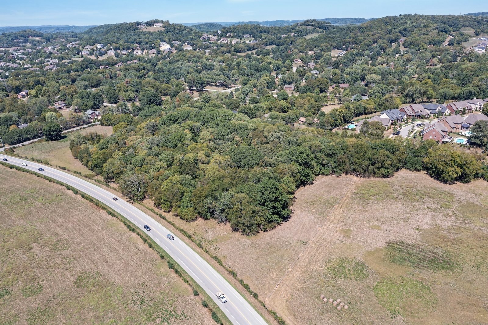 Sweeping aerial of the ten acre Franklin property and its wooded surroundings