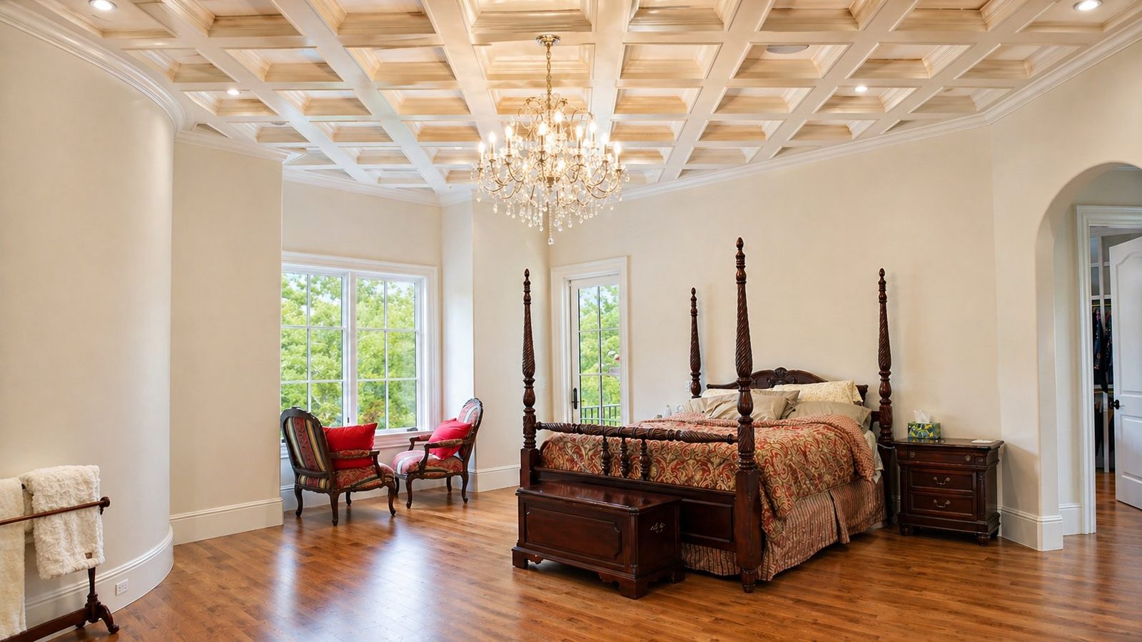 Primary bedroom with coffered ceiling and a curved wall of windows